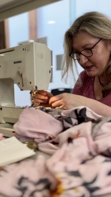 Workshop participant sewing floral fabric on a Bernina machine