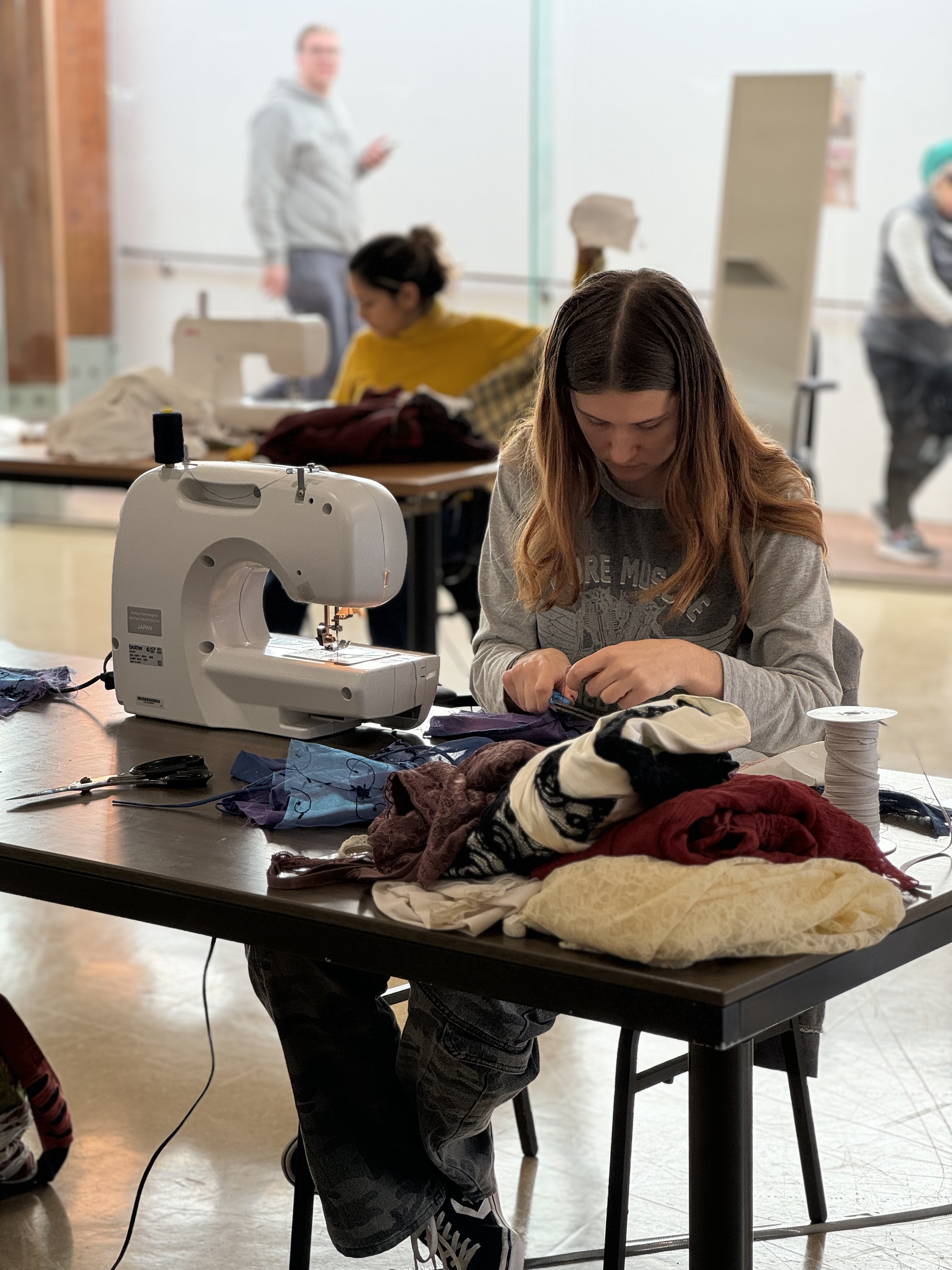 Workshop participant sewing at a table