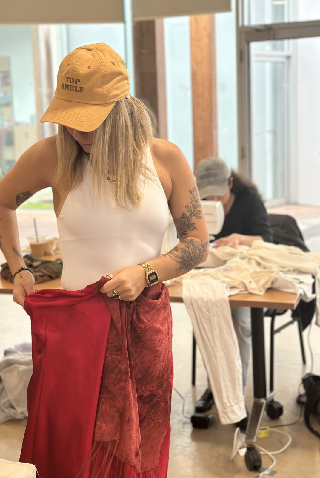 Participant holding up a red skirt she is re-making