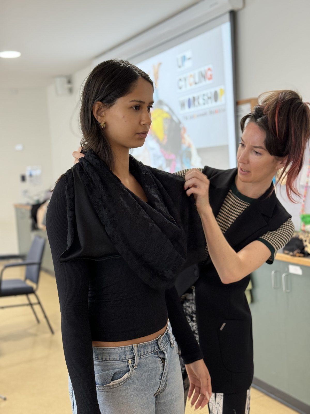 Erica fitting a draped black top on a participant