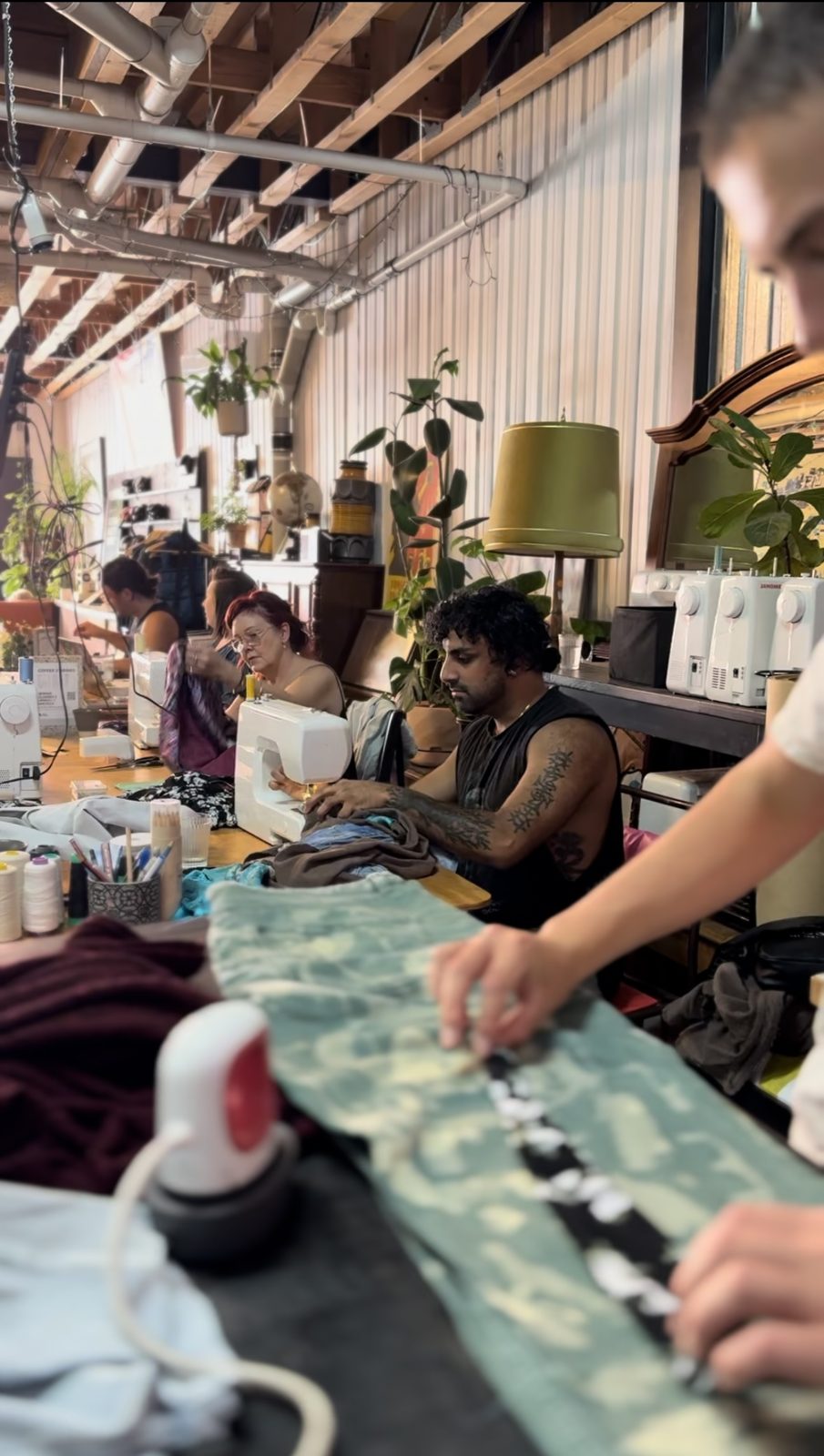 Participants sewing along a long table at Into Carry